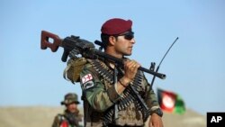 Afghan National Army soldiers stand guard at a checkpoint on the outskirts of Kabul, Afghanistan, Monday, Aug. 21, 2017. (AP Photo/Rahmat Gul)