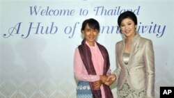 Aung San Suu Kyi (kiri) disambut oleh Perdana Menteri Thailand Yingluck Shinawatra dalam jamuan makan malam untuk seluruh peserta Forum Ekonomi Dunia di Bangkok, Thailand (31/5).