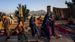 Afghan women walk through a second-hand market where many families sold their belongings before leaving the country or due to financial struggle, in Kabul, Sept. 15, 2021.