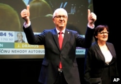 FILE - Presidential candidate Jiri Drahos, accompanied by his wife, Eva, arrives to address reporters after the announcement of preliminary results of the presidential elections in Prague, Czech Republic, Jan. 13, 2018.