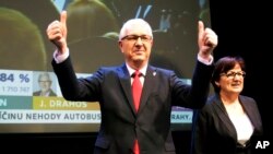 Presidential candidate Jiri Drahos, accompanied by his wife Eva, arrives to address the media after the announcement of preliminary results of the presidential elections in Prague, Czech Republic, Jan. 13, 2018.