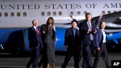 President Donald Trump walks with Tony Kim, third right, Kim Dong Chul, right, and Kim Hak Song, behind Trump, the three Americans detained in North Korea, as they arrive at Andrews Air Force Base in Md., May 10, 2018. Walking with Trump is Vice President