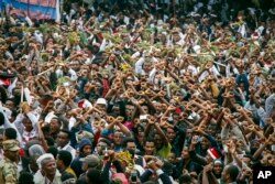 FILE - In this Sunday, Oct. 2, 2016 file photo, protesters chant slogans against the government during a march in Bishoftu, in the Oromia region of Ethiopia.