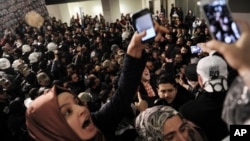 FILE - Journalists react as riot police enter the headquarters of Turkey's largest-circulation newspaper Zaman in Istanbul, March 4, 2016.