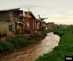 Although drainage channels have been built, homes are often built right up to the edge. Waste dumped in such channels often leads to flooding in low lying homes. (E. Paulat/VOA)