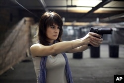 FILE - Maria Butina, a gun-rights activist poses for a photo at a shooting range in Moscow, Russia, April 22, 2012.