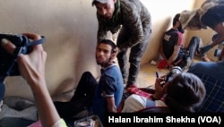 Soldiers show off captured suspected militants in Mosul, Iraq, July 5, 2017. Officials say most suspects in custody were not captured in battle, but as they tried to blend into the population after the war.