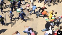 Zimbabwean riot police clash with protesters during a demonstration against the introduction of bond notes by the Reserve Bank of Zimbabwe, in Harare, Aug. 17, 2016.