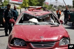 An Afghan man drives his damaged car after a suicide attack in Kabul, Afghanistan.