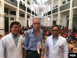 លោកវេជ្ជបណ្ឌិតសាស្ត្រាចារ្យ ហេង សុទ្ធី (ឆ្វេង) អនុប្រធានមន្ទីរពេទ្យគន្ធបុប្ជា លោកវេជ្ជបណ្ឌិត ឡូរ៉េង ដេនីស នាយក​ប្រតិបត្តិ​ប្រចាំ​ការ​នៃ​មូលនិធិ​គន្ធបុប្ជាស្វីស (កណ្តាល) និង​លោក​វេជ្ជបណ្ឌិតសាស្ត្រាចារ្យ គី សាន់ទី ប្រធាន​មន្ទីរពេទ្យ​គន្ធបុប្ជា​ភ្នំពេញ ចុះត្រួតពិនិត្យដំណើរការព្យាបាលអ្នកជំងឺនៅមន្ទីរពេទ្យគន្ធបុប្ផា កាលពីខែមិថុនា ឆ្នាំ២០១៩។ (ធីតា វីន/VOA)