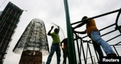 Construction workers work on a huge Christmas tree in an attempt to construct the world's tallest Christmas tree, in Colombo, Sri Lanka, Dec. 20, 2016.