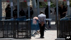 Seorang warga Palestina berjalan melewati detektor logam di komplek masjid Al Aqsa di Yerusalem (19/7).