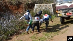 Myanmar Red Cross members carry injured victim during clash between government troops and Kokang rebels in northeastern Shan State, northeast of Yangon, Feb. 17, 2015.