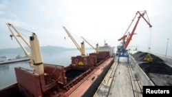 A cargo ship is loaded with coal during the opening ceremony of a new dock at the North Korean port of Rajin in 2014. United Nations Security Council sanctions target North Korea's coal exports.