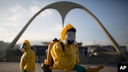 FILE - a health workers stands in the Sambadrome spraying insecticide to combat the Aedes aegypti mosquito that transmits the Zika virus in Rio de Janeiro, Brazil.