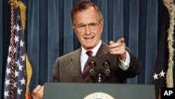 FILE - President George H.W. Bush acknowledges a reporter during a news conference at the White House, Dec. 5, 1991.