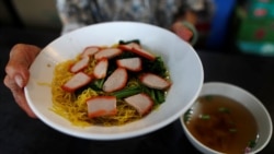 Hawker Leong Yuet Meng, 90, of Nam Seng Noodle House, sells a bowl of wonton noodle soup at her shop in Singapore. February 22, 2019. REUTERS/Edgar Su