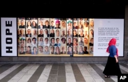 A woman walks by an ad promoting diversity and tolerance, at a shopping mall in Stockholm, Sweden, Aug. 31, 2018.