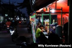 Orang-orang makan malam di tenda jajanan kaki lima saat pelonggaran PPKM di tengah pandemi COVID-19, di Jakarta, 28 Juli 2021. (Foto: REUTERS/Willy Kurniawan)