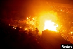 香港理工大学的抗议者站在燃烧的大火旁。（2019年11月18日）