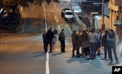People evacuated from the Quest On the Terrace Hotel gather outside the hotel in Wellington after a 6.6 earthquake based around Cheviot in the South island shock the capital, Nov. 14, 2016.