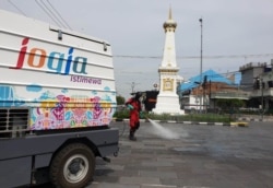 Petugas dari BPBD DIY melakukan penyemprotan desinfektan di kawasan Tugu, 22 Maret 2020. (Foto: Courtesy/Humas Pemda DIY)