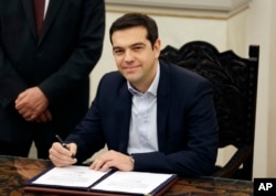 Greece's Prime Minister Alexis Tsipras poses for the photographers after taking a secular oath at the Presidential Palace in Athens, Jan. 26, 2015.