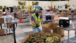 A worker puts bags of sweet potatoes in a container in the warehouse of the Alameda County Community Food Bank in Oakland, Calif., on Nov. 5, 2021.