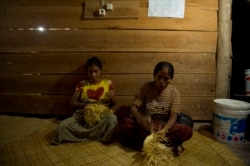 Dua perempuan Sumba sedang menganyam keranjang di Desa Kamanggih, Sumba, 19 Maret 2014. (Foto: AFP)
