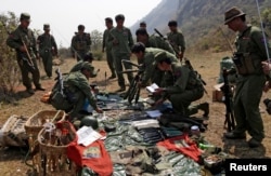 Rebel soldiers of the Myanmar National Democratic Alliance Army (MNDAA) examine weapons and ammunition at a military base in Kokang region, March 10, 2015.