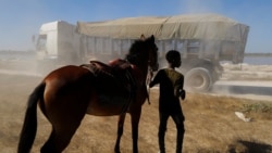 Fallou Diop holds onto a young female horse named Raissa Betty, whom he is currently training to compete with in the future, as they cross a road along Lac Rose, also known as Lake Retba, in Niaga, Rufisque region, Senegal, January 2