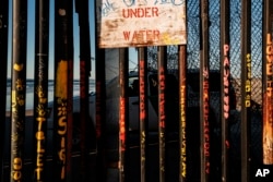 A border patrol office inside his vehicle guards the border fence at the U.S. side of San Diego, Calif., as seen from Tijuana, Mexico, Jan. 2, 2019.