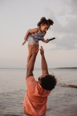 Father and daughter playing by the water.