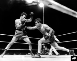 FILE - Jake LaMotta, right, is seen fighting Marcel Cerdan at Briggs Stadium, in Detroit, Michigan, June 16, 1949.