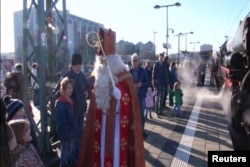 Anak-anak di Munich, Jerman, menerima kunjungan kejuta dari St. Nicholas sebelum mereka naik ke kereta api kuno untuk perjalanan spesial Natal bersamanya.