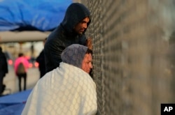 Yenly Herrera, front, and Yenly Morales, immigrants from Cuba seeking asylum in the United States, wait on the International Bridge, Nov. 2, 2018, in Matamoros, Mexico.