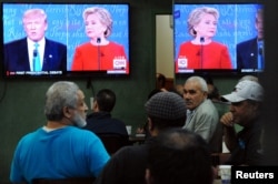 FILE -- People watch the first U.S. presidential debate in a restaurant, Sept. 26, 2016, in the Queens borough of New York City.