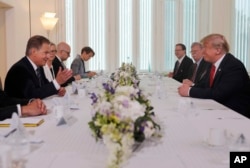 Finnish President Sauli Niinisto, left, and U.S. President Donald Trump, right, sit down for a working breakfast at Niinisto's official residence in Helsinki, Finland, Monday, July 16, 2018.