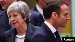 Britain's Prime Minister Theresa May and French President Emmanuel Macron take part in a European Union leaders summit in Brussels, Dec. 13, 2018.