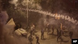 Manifestantes se alejan del gas lacrimógeno arrojado por la policía nacional durante enfrentamientos en Barcelona. (AP)