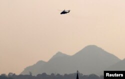 An MI-35M military helicopter flies over Christian church in Lashio, February 19, 2015.
