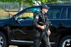 A Capitol Hill Police officer walks past an automobile with the driver's window damaged at the scene of a shooting in Alexandria, Virginia, June 14, 2017.