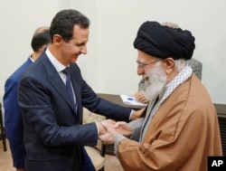 In this photo released by the Syrian official news agency SANA, Syrian President Bashar al-Assad, left, shakes hands with Iranian Supreme Leader Ayatollah Ali Khamenei, before their meeting in Tehran, Syria, Feb. 25, 2019.