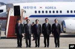 South Korea's national security director Chung Eui-yong, center, National Intelligence Service Chief Suh Hoon, second left, and other delegators pose before boarding an aircraft as they leave for Pyongyang at a military airport.
