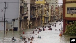 People move through flooded streets in Havana after the passage of Hurricane Irma, in Cuba, Sept. 10, 2017.