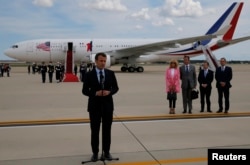 French President Emmanuel Macron speaks to the news media after arriving with his wife Brigitte Macron for their state visit to Washington at Joint Base Andrews in Maryland, April 23, 2018.