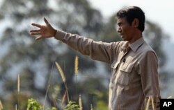 រូបឯកសារ៖ លោក ឈុត វុទ្ធី សកម្មជន​ការពារ​ព្រៃឈើ​ដ៏​ឆ្នើម​ម្នាក់​របស់​កម្ពុជា លើក​ដៃ​បង្ហាញ​តំបន់​ព្រៃ​នៅ​ឧទ្យានជាតិបុទុមសាគរ ខេត្តកោះកុង កាលពីខែ​កុម្ភៈ ឆ្នាំ២០១២។