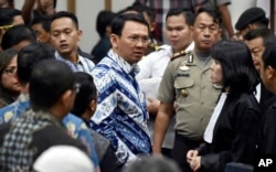 Jakarta Governor Basuki "Ahok" Tjahaja Purnama, center, talks to his lawyers after his sentencing hearing at a court in Jakarta, Indonesia, Tuesday, May 9, 2017.