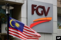 Bendera nasional Malaysia dipajang di luar FGV Holdings Berhad, salah satu perusahaan kelapa sawit terbesar Malaysia, di Kuala Lumpur, Kamis, 1 Oktober 2020. (Foto: AP)
