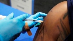 In this July 27, 2021 file photo, Timontre Graham, 21, a senior at Jackson State University and a member of the school's football team, receives his COVID-19 vaccination at the Rose E. McCoy Auditorium on the Jackson State University school in Jackson, Miss. ( AP Photo/Rogelio V. Solis, File)